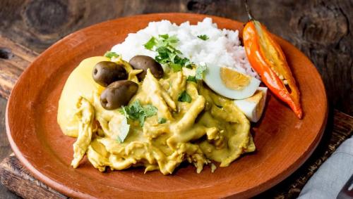 aji-de-gallina-with-olives-egg-and-rice-on-clay-plate
